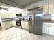 A bright kitchen with white cabinets, stainless steel appliances, tile backsplash, and tile flooring at 10063 40Th N St # 3, Pinellas Park, FL 33782