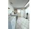 Well lit laundry room with washer, dryer, cabinets, shelving, and tile floors at 10063 40Th N St # 3, Pinellas Park, FL 33782