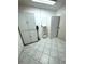 White laundry room with storage cabinets, shelving, tile floors and a vacuum cleaner at 10063 40Th N St # 3, Pinellas Park, FL 33782