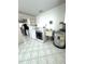 Laundry room with washer, dryer, sink, hot water tank, and white tile floors at 10063 40Th N St # 3, Pinellas Park, FL 33782