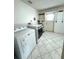 Bright laundry room with washer, dryer, tile floors and a rear exit door at 10063 40Th N St # 3, Pinellas Park, FL 33782