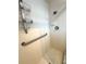 Shower stall featuring white tiles, a shower head, a grab bar, and a shower rack at 10063 40Th N St # 3, Pinellas Park, FL 33782