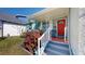 Inviting front porch with decorative railing, steps, and vibrant red door at 1011 W Charter St, Tampa, FL 33602