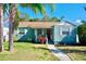 Charming single-story home featuring a tidy front yard, light blue paint and red front door at 1011 W Charter St, Tampa, FL 33602