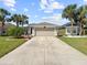 Residential home featuring a long driveway, two-car garage, and well manicured landscaping at 10309 Buncombe Way, San Antonio, FL 33576