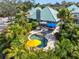 Aerial view of a private backyard pool surrounded by lush tropical landscaping and a stone patio at 10351 Longwood Dr, Seminole, FL 33777