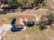 Aerial view of a single-story house, showing the roof, driveway, and surrounding landscape at 11054 Liberto Rd, Weeki Wachee, FL 34614