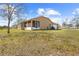 Back exterior of home with a screened-in porch, a yard, and an attached garage at 11054 Liberto Rd, Weeki Wachee, FL 34614