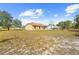 Spacious backyard with lush grass, the rear of the home, and a screened-in porch at 11054 Liberto Rd, Weeki Wachee, FL 34614