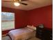 Bedroom featuring a bed, window overlooking the yard, dresser, and red accent wall at 11054 Liberto Rd, Weeki Wachee, FL 34614
