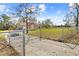 Spacious front yard featuring a gated entrance and expansive green space at 11054 Liberto Rd, Weeki Wachee, FL 34614