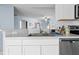 Clean kitchen featuring white cabinetry, stainless steel appliances, and a view into the living room at 11054 Liberto Rd, Weeki Wachee, FL 34614