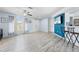 Bright living room with modern floors, blue accent wall, ceiling fan, and ample natural light at 11054 Liberto Rd, Weeki Wachee, FL 34614