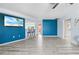 Bright living room with modern floors, blue accent wall, and open layout to other rooms at 11054 Liberto Rd, Weeki Wachee, FL 34614