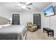 Inviting main bedroom featuring soft carpet, ceiling fan, and a cozy recliner at 11054 Liberto Rd, Weeki Wachee, FL 34614