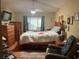Cozy bedroom with wooden furniture, a ceiling fan, and natural light from the window at 12139 Buffington Ln, Riverview, FL 33579