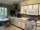 Bright kitchen features white appliances and cabinets, with a breakfast nook and colorful chairs at 12139 Buffington Ln, Riverview, FL 33579
