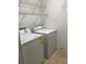 Bright laundry room with white washer and dryer and metal shelving for storage at 12139 Buffington Ln, Riverview, FL 33579