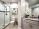 Modern bathroom featuring glass shower, neutral tile, vanity and artwork at 130 Riviera Dunes Way # 606, Palmetto, FL 34221