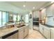 Modern kitchen with stainless steel appliances, marble counters, and eat-in bar at 130 Riviera Dunes Way # 606, Palmetto, FL 34221