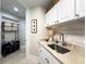 Well-organized laundry room with white cabinetry, ample counter space, and convenient storage options at 130 Riviera Dunes Way # 606, Palmetto, FL 34221