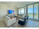 Bright living room with floor-to-ceiling windows offering stunning water views and access to outdoor balcony at 130 Riviera Dunes Way # 606, Palmetto, FL 34221