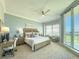 Serene main bedroom with a private balcony, a sitting area, and a dedicated workspace at 130 Riviera Dunes Way # 606, Palmetto, FL 34221