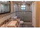 Bathroom featuring a large tiled shower, granite countertop, and a framed mirror at 13305 Whitby Rd, Hudson, FL 34667