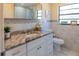 Stylish bathroom with modern vanity, granite countertop, and decorative mirror at 13305 Whitby Rd, Hudson, FL 34667