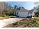 Traditional home featuring an attached two-car garage, spacious driveway, and neatly kept lawn, under a sunny sky at 13305 Whitby Rd, Hudson, FL 34667
