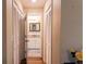 Hallway featuring wood flooring, access to the bathroom, and multiple storage closets at 13305 Whitby Rd, Hudson, FL 34667
