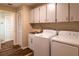 Convenient laundry room featuring modern washer and dryer, sink, and storage cabinets at 13305 Whitby Rd, Hudson, FL 34667