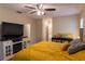 Bright main bedroom featuring a ceiling fan, television, and a view to the bathroom at 13305 Whitby Rd, Hudson, FL 34667