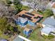 Aerial shot of a home with solar panels, a fenced backyard, and a storage shed at 1579 Magnolia Dr, Clearwater, FL 33756