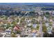 Aerial view of a neighborhood with residential homes near a lake and a busy street at 1579 Magnolia Dr, Clearwater, FL 33756