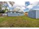 Backyard featuring a blue house with a storage shed at 1579 Magnolia Dr, Clearwater, FL 33756