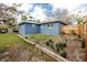 Lush backyard showcasing a blue home exterior and well-defined garden area with wooden border at 1579 Magnolia Dr, Clearwater, FL 33756