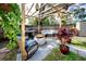 Backyard featuring outdoor furniture under a wood pergola with hanging plants at 1579 Magnolia Dr, Clearwater, FL 33756