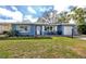 Inviting home exterior featuring a brick porch, blue paint, and well-maintained lawn at 1579 Magnolia Dr, Clearwater, FL 33756