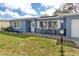 Cozy blue home with a welcoming front porch seating area on a well maintained lawn at 1579 Magnolia Dr, Clearwater, FL 33756