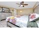 This bedroom features a ceiling fan and a beautiful floral comforter at 1579 Magnolia Dr, Clearwater, FL 33756
