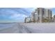 Sandy white beach with the ocean, buildings in background and blue sky at 1600 Gulf Blvd # 512, Clearwater, FL 33767