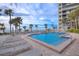 Resort-style pool area with ocean views, lounge chairs, and palm trees at 1600 Gulf Blvd # 512, Clearwater, FL 33767