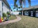 Spacious backyard with verdant grass, a brick pathway, and a privacy fence surrounded by flourishing trees at 19309 Red Sky Ct, Land O Lakes, FL 34638