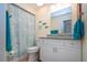 Charming bathroom featuring white vanity with granite countertop, tiled shower, seashell curtain, and nautical-themed décor accents at 2016 E View Dr, Sun City Center, FL 33573