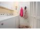 Well-lit laundry room with white cabinetry, washer, dryer and door leading to the exterior at 2016 E View Dr, Sun City Center, FL 33573
