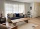 Bright living room with sheer curtains, a comfortable sofa, and a rustic wooden coffee table at 2016 E View Dr, Sun City Center, FL 33573