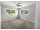 Cozy bedroom with plush carpeting, two windows, and a ceiling fan for added comfort at 2391 66Th S Ter, St Petersburg, FL 33712