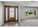 Inviting entryway features a decorative glass front door, neutral paint, and carpeted living room at 2391 66Th S Ter, St Petersburg, FL 33712