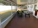 Screened-in patio with an outdoor chair, table and a partially-view of white fence backyard at 2391 66Th S Ter, St Petersburg, FL 33712